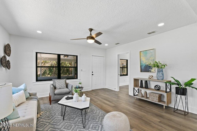 living room featuring visible vents, recessed lighting, a textured ceiling, and wood finished floors