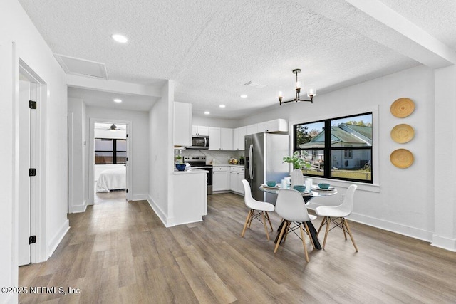 dining room with recessed lighting, a chandelier, baseboards, and wood finished floors