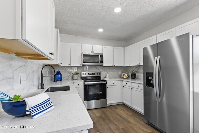 kitchen with a sink, stainless steel appliances, dark wood-type flooring, and backsplash