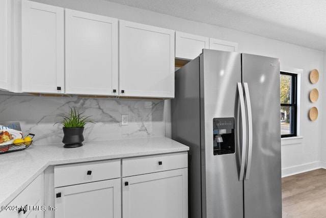 kitchen with white cabinetry, wood finished floors, stainless steel refrigerator with ice dispenser, and backsplash