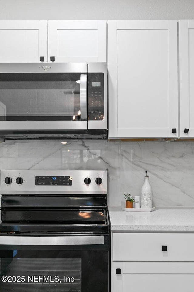 kitchen featuring white cabinets, tasteful backsplash, and appliances with stainless steel finishes