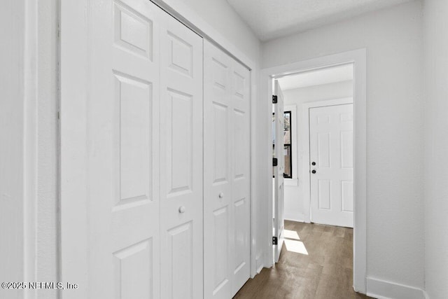 corridor with baseboards and dark wood-type flooring