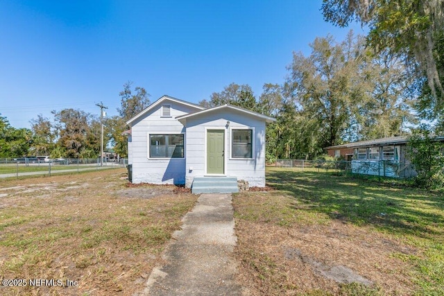 bungalow-style house featuring entry steps, a front yard, and fence