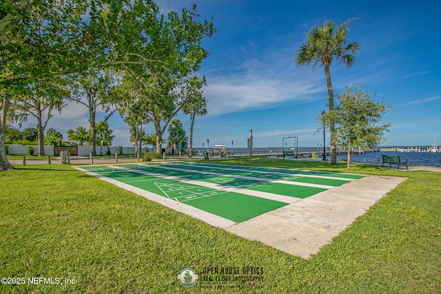 view of community with shuffleboard and a yard