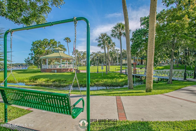 surrounding community featuring a gazebo, a lawn, and a water view