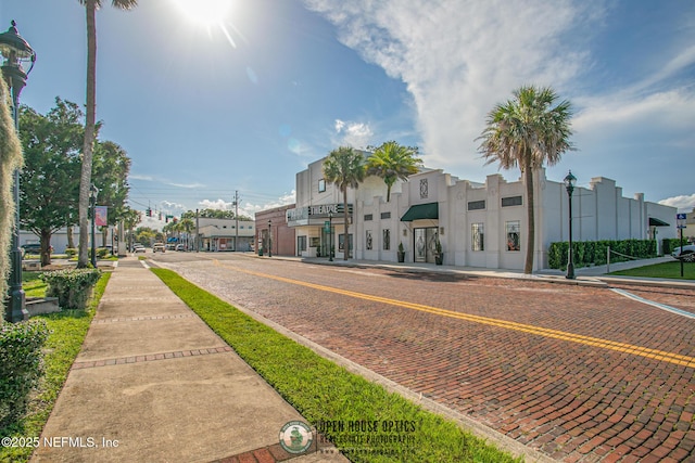 view of street featuring sidewalks, curbs, and street lights