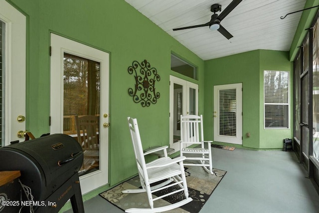 sunroom featuring a ceiling fan and french doors