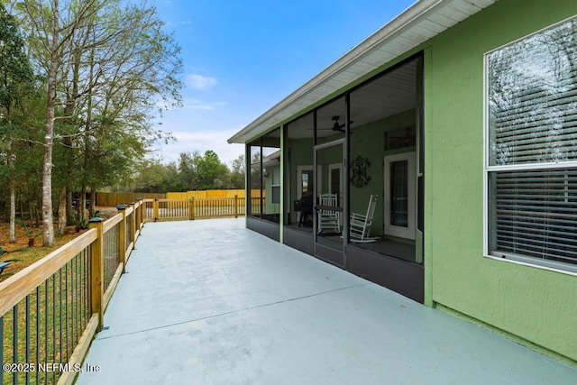 view of patio / terrace featuring fence and a sunroom