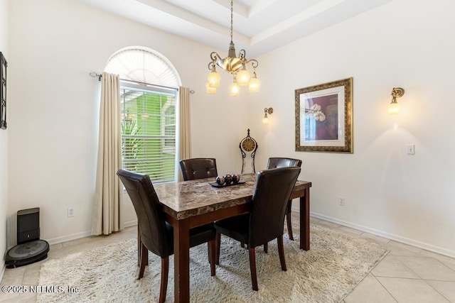 dining room featuring light tile patterned floors, baseboards, a notable chandelier, and a raised ceiling