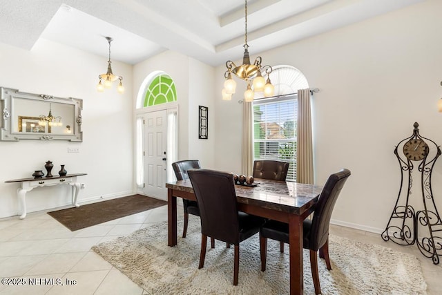 dining room with light tile patterned floors, a high ceiling, a raised ceiling, and baseboards