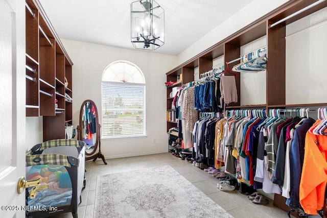 walk in closet featuring tile patterned flooring and a chandelier