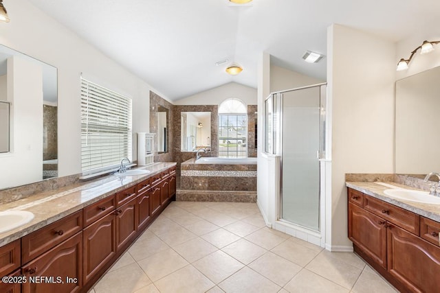 bathroom featuring tile patterned flooring, vaulted ceiling, double vanity, and a sink