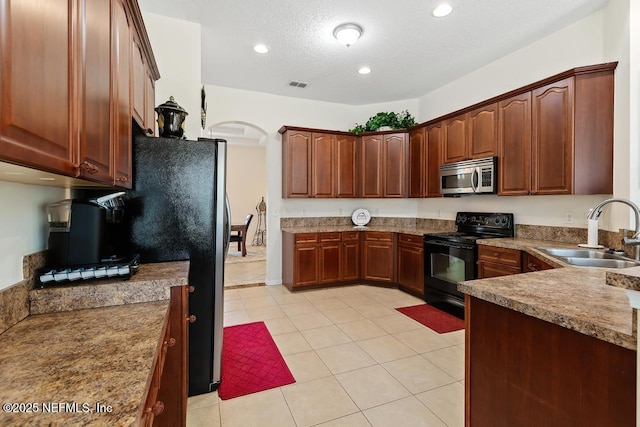 kitchen with visible vents, a sink, black electric range, a textured ceiling, and stainless steel microwave