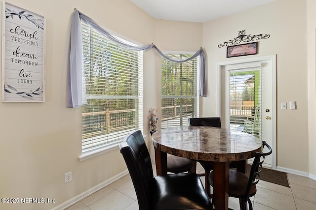 dining area with light tile patterned floors, a healthy amount of sunlight, and baseboards