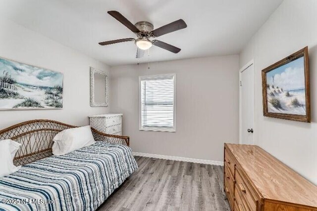 bedroom with wood finished floors, baseboards, and ceiling fan