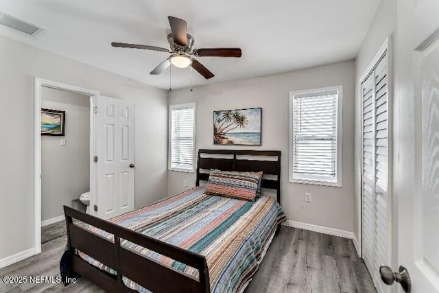 bedroom with visible vents, multiple windows, and wood finished floors