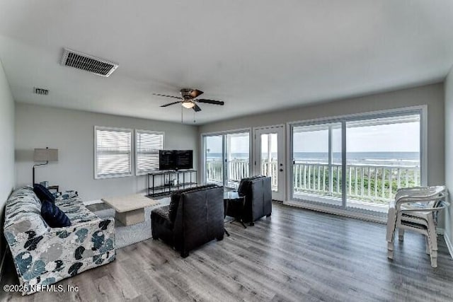 living area featuring ceiling fan, visible vents, and wood finished floors