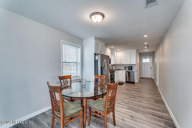 dining room with recessed lighting, visible vents, light wood-style flooring, and baseboards