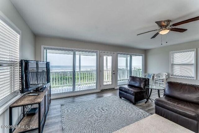 living area with a ceiling fan and wood finished floors