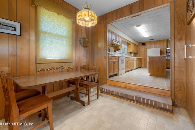 dining room with wooden walls and light floors