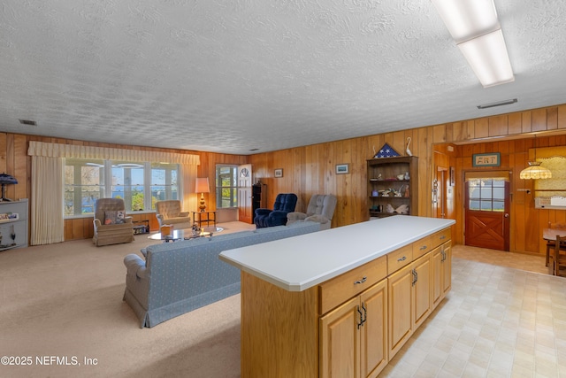 kitchen featuring visible vents, open floor plan, a center island, and light countertops