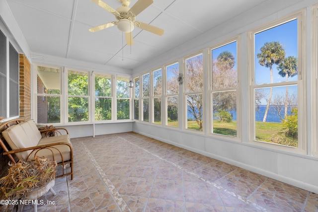 unfurnished sunroom featuring a ceiling fan