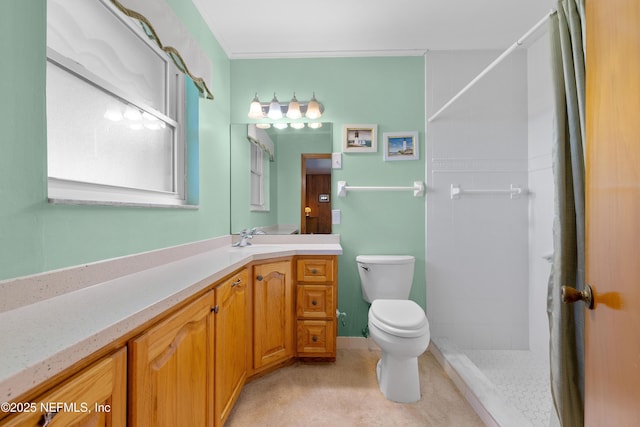 full bath featuring tiled shower, toilet, and vanity