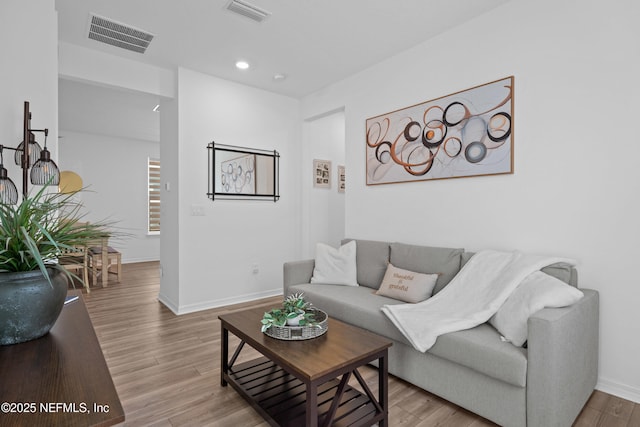 living room featuring visible vents, recessed lighting, baseboards, and wood finished floors