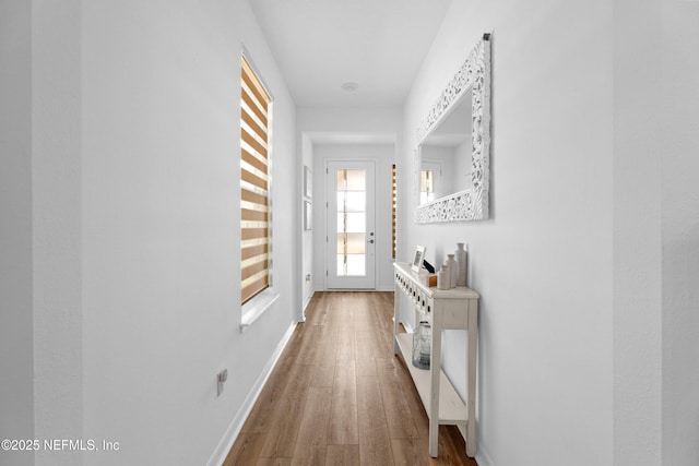 hall featuring wood finished floors and baseboards