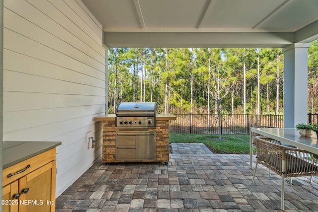 view of patio featuring area for grilling, a grill, outdoor dining space, and fence