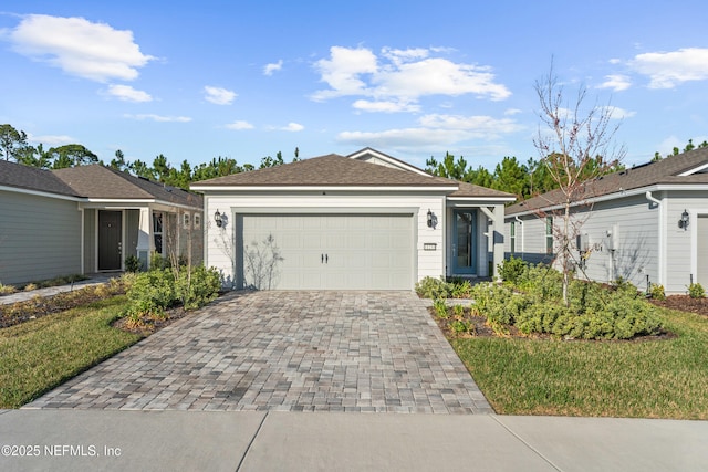 ranch-style home featuring decorative driveway and a garage