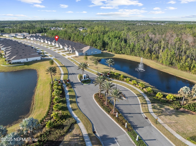 drone / aerial view featuring a wooded view and a water view