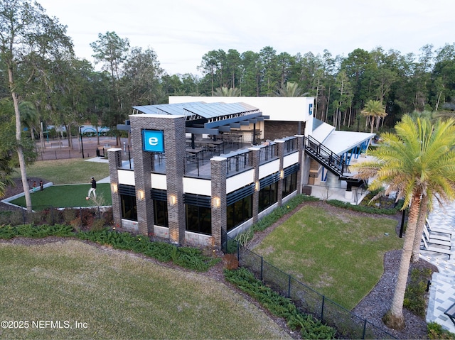 back of property featuring a lawn and fence