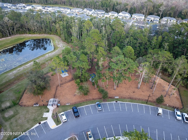 drone / aerial view featuring a wooded view and a water view