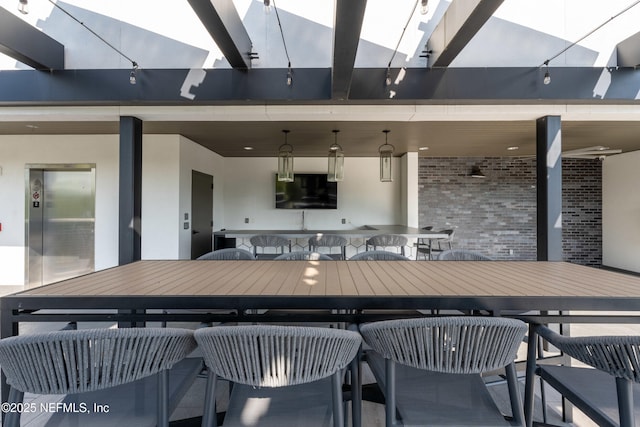 view of patio featuring elevator and outdoor dry bar