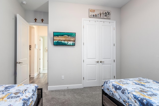 carpeted bedroom with baseboards and a closet