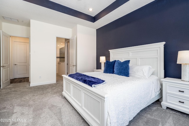 bedroom with baseboards, visible vents, carpet floors, and a textured ceiling
