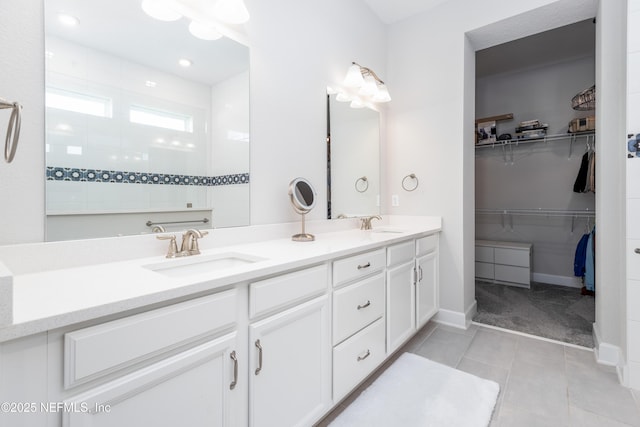 full bathroom with tile patterned floors, a sink, a walk in closet, walk in shower, and double vanity
