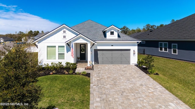 view of front facade featuring board and batten siding, decorative driveway, a front lawn, a garage, and a shingled roof