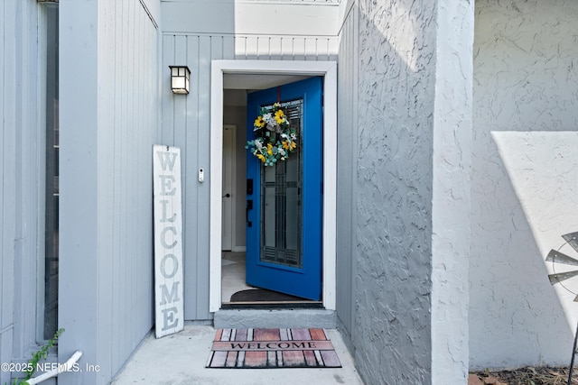 doorway to property featuring stucco siding