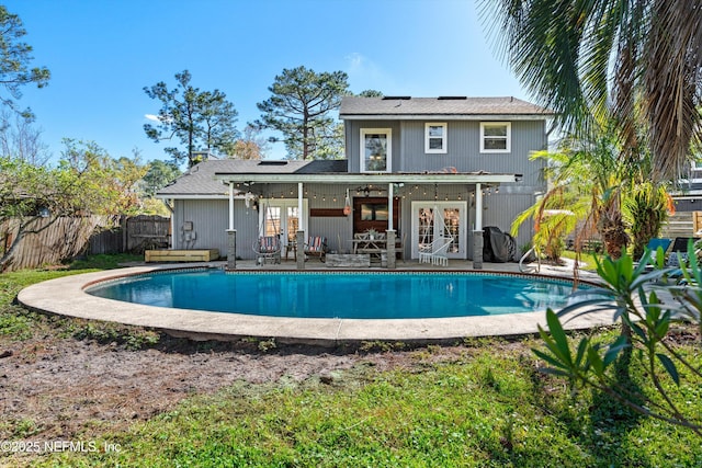 back of house with french doors, a fenced in pool, a fenced backyard, and a patio area