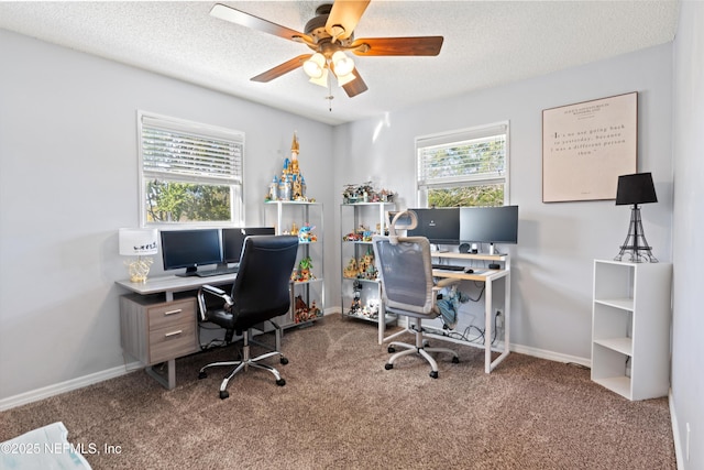 carpeted home office featuring baseboards, a textured ceiling, and ceiling fan