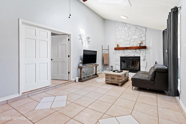 living room with vaulted ceiling, light tile patterned flooring, a fireplace, and a textured ceiling