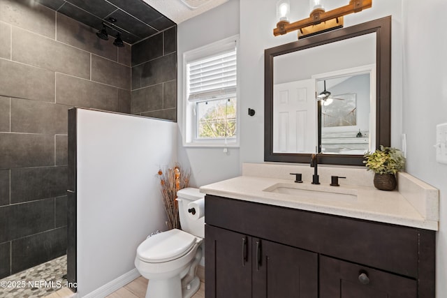 bathroom featuring a ceiling fan, toilet, walk in shower, and vanity