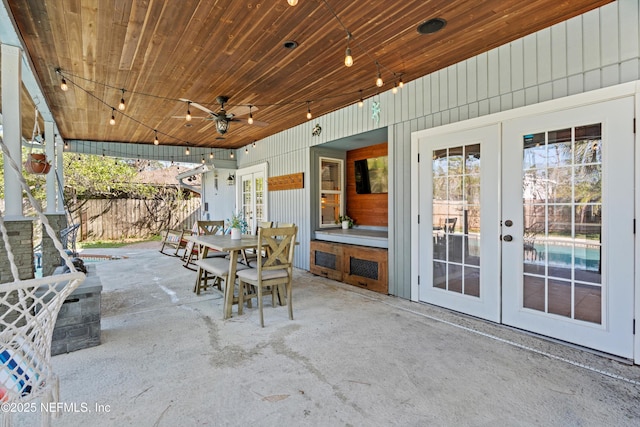 view of patio with french doors, outdoor dining area, ceiling fan, and fence