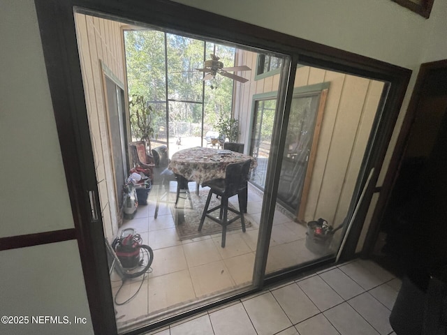 doorway to outside featuring light tile patterned flooring and a ceiling fan