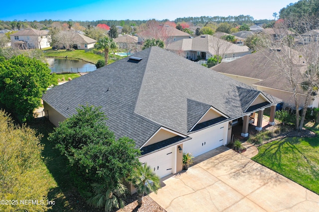 drone / aerial view featuring a residential view and a water view