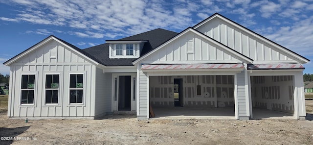 modern farmhouse style home featuring board and batten siding, a shingled roof, metal roof, a garage, and a standing seam roof