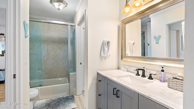 bathroom featuring vanity, toilet, and bath / shower combo with glass door