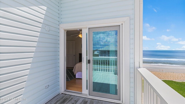 property entrance with a balcony, a view of the beach, and a water view